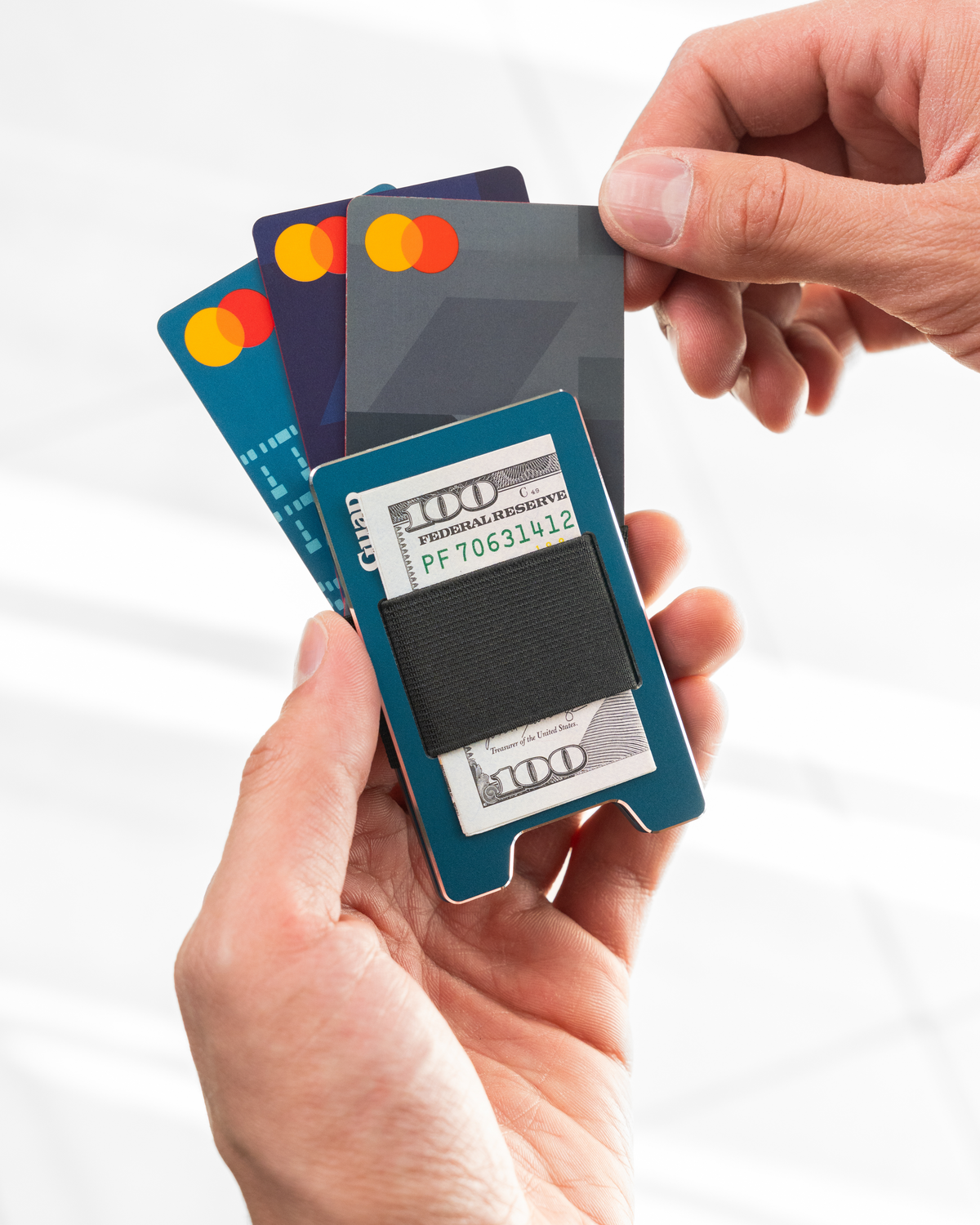 Midnight Blue Guap slim wallet holding folded bills under the elastic band, cards fanned out